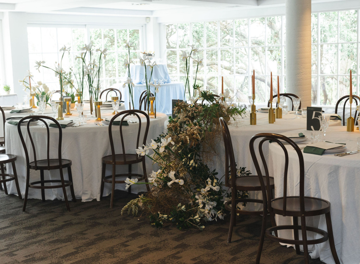 An elegant dining room at Orakei Bay, Auckland, a modern waterside venue with large windows providing natural light.