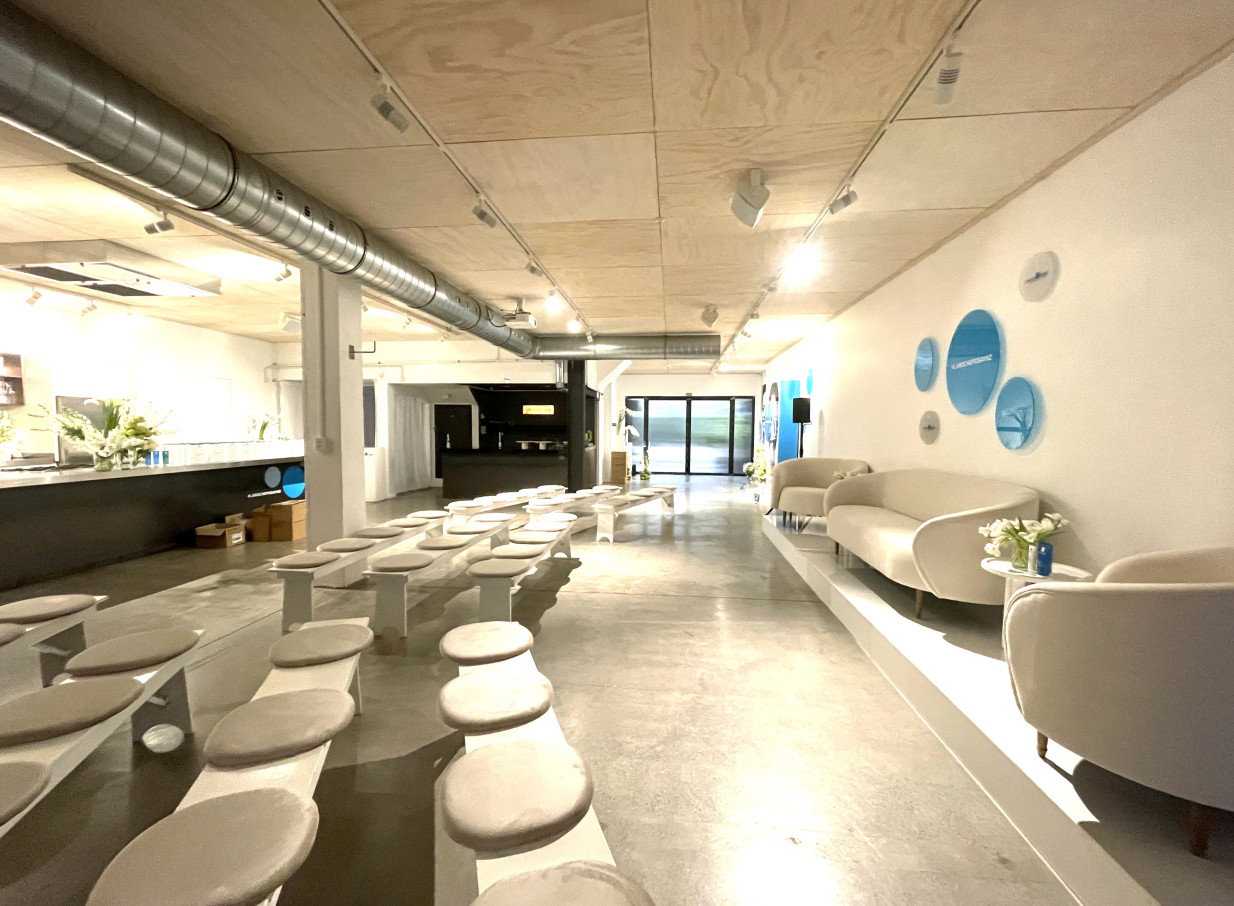 The contemporary industrial event space at Space On Crummer, Auckland, features theatre-style seating and a comfortable lounge area.