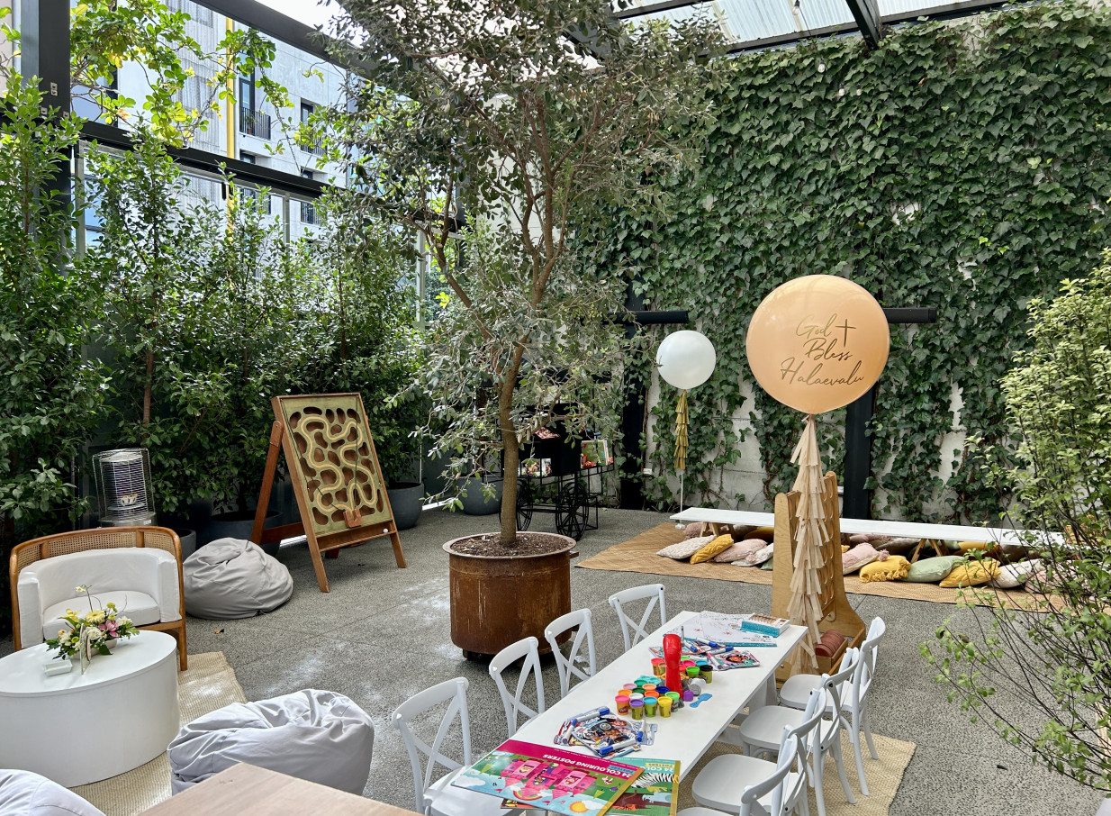 An industrial-chic covered courtyard at Space On Crummer in Auckland, adorned with greenery and set up for a vibrant, festive event.