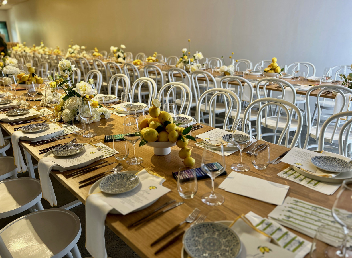 The contemporary industrial-chic private dining room at Space On Crummer, Auckland, set for an elegant event with lemon and white florals.