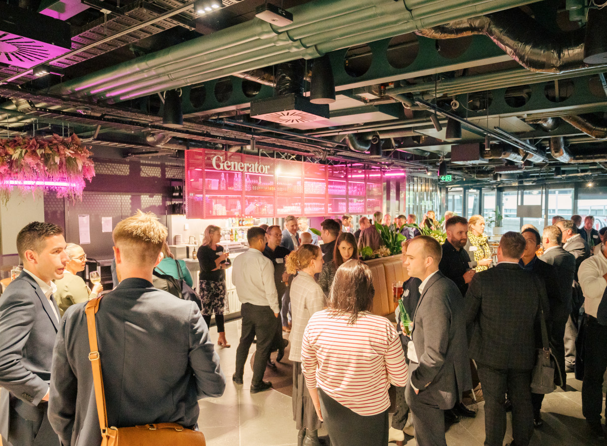 A lively networking event takes place in the contemporary bar area of Bowen Campus by Precinct Flex in Wellington.