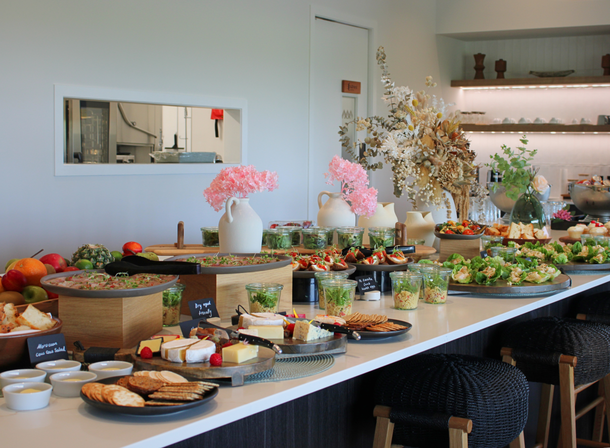 A lavish buffet in the modern luxury dining space of Te Karaka Lodge in Waikato, reflecting its natural surroundings.