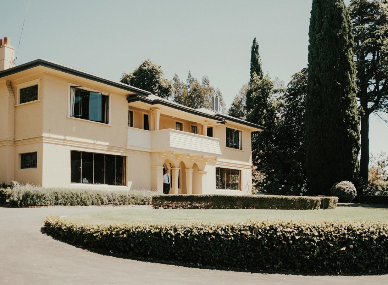 Kōtare Estate, a 1920s Mediterranean-style villa in Hawke's Bay, viewed from its manicured lawns and driveway.