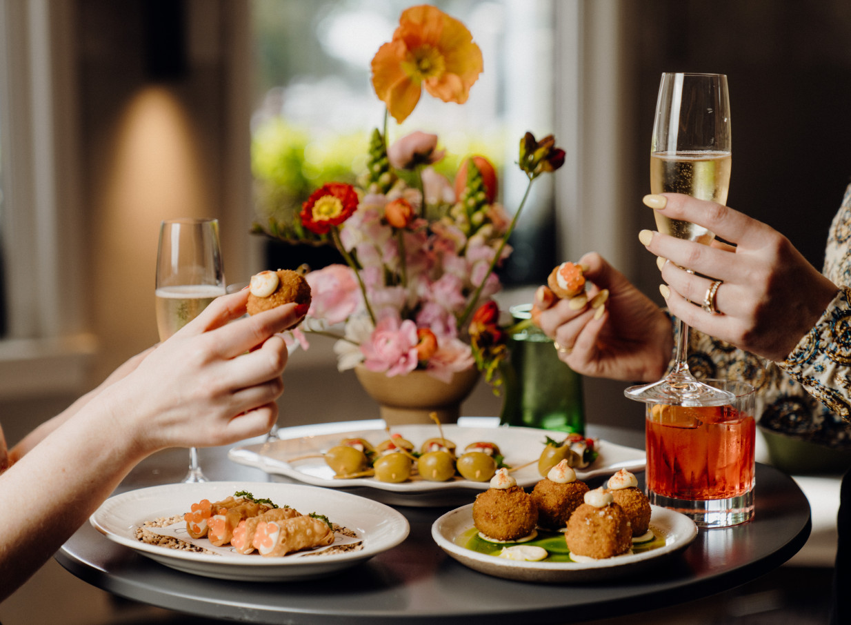 Enjoying champagne and appetizers in the luxuriously quirky, design-led setting of QT Auckland.