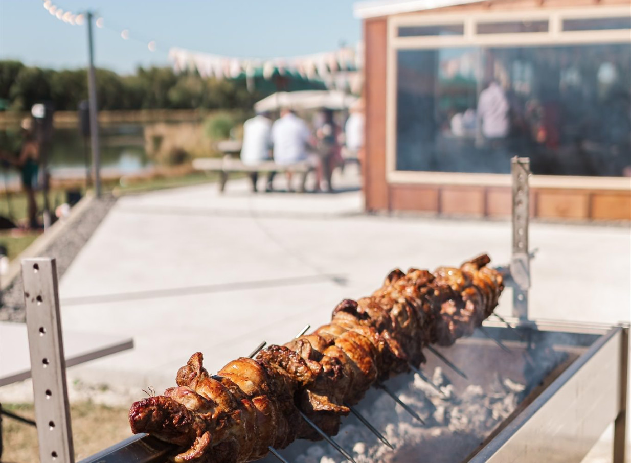 An outdoor spit roast catering a rustic lakeside event at Backpaddock Lakes in Hawke's Bay.