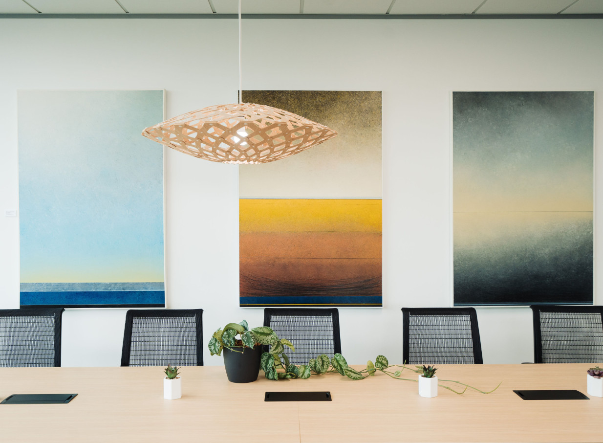 A modern design meeting room at CA Auckland Conference Centre in Auckland, featuring abstract art and a distinctive pendant light.