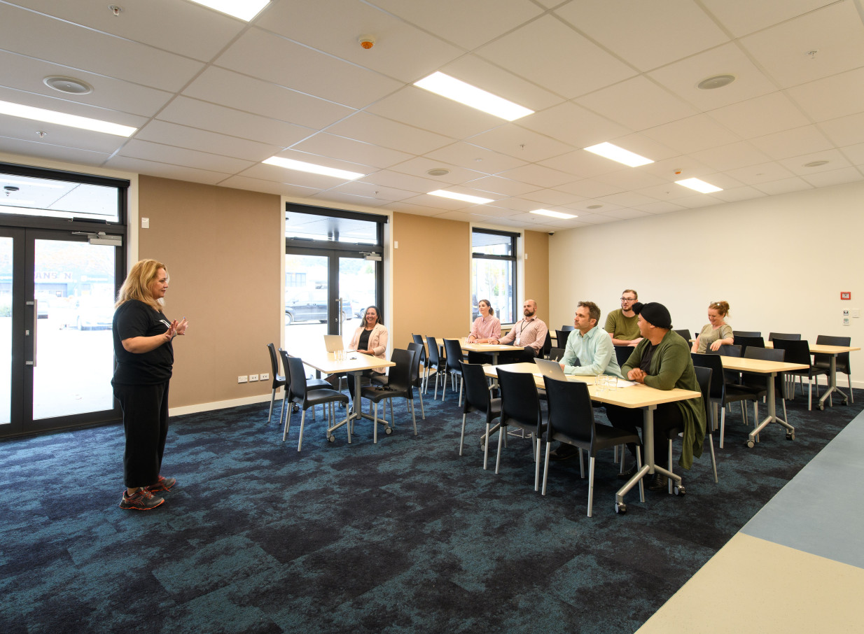 A presenter addresses attendees in a contemporary, light-filled meeting room at Whirinaki Whare Taonga, Upper Hutt.