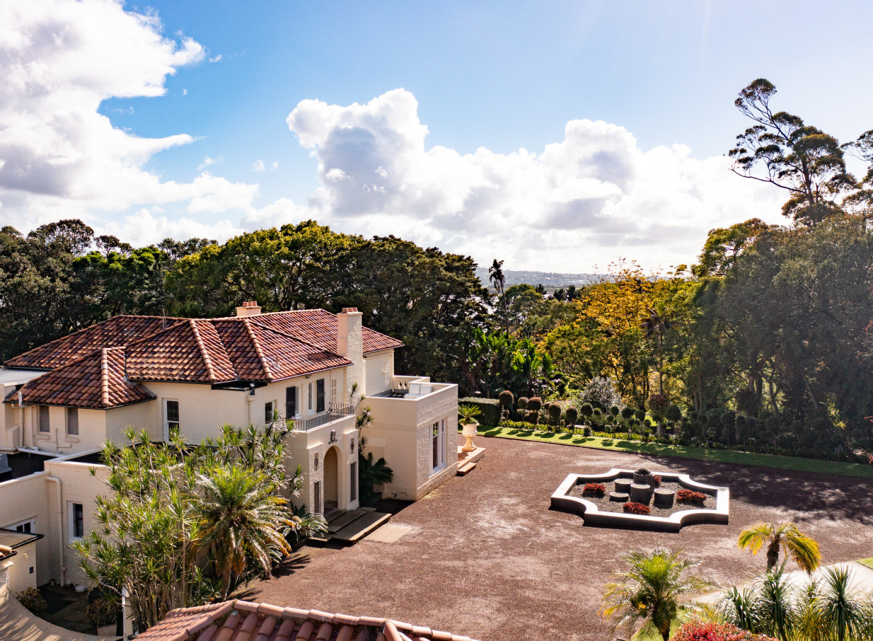 An aerial view of the Spanish-style Puketutu Island Estate in Auckland, featuring its elegant homestead and landscaped grounds.
