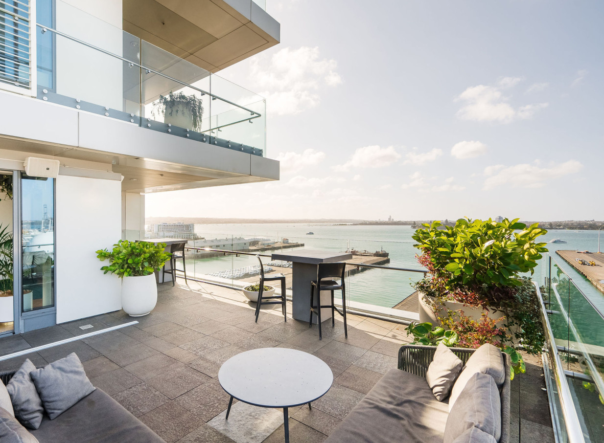 A modern outdoor terrace at Britomart Place by Precinct Flex in Auckland offers stunning waterfront views.