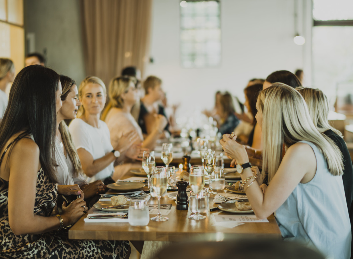 A group of guests enjoys a seated dining event in the elegant, modern setting of Fabric Cafe Bistro in Auckland.
