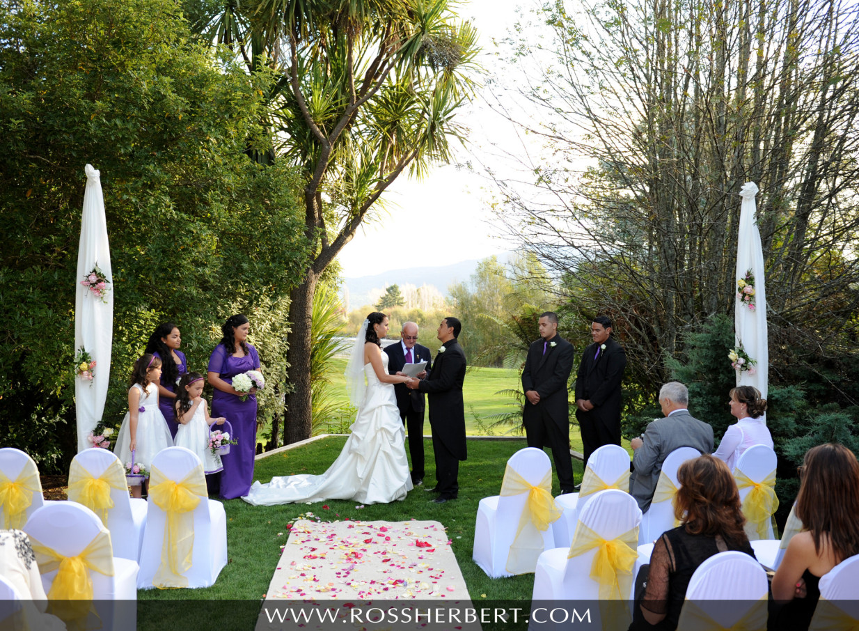 An outdoor wedding ceremony in the lush gardens of the iconic Tongariro Lodge, Taupo.
