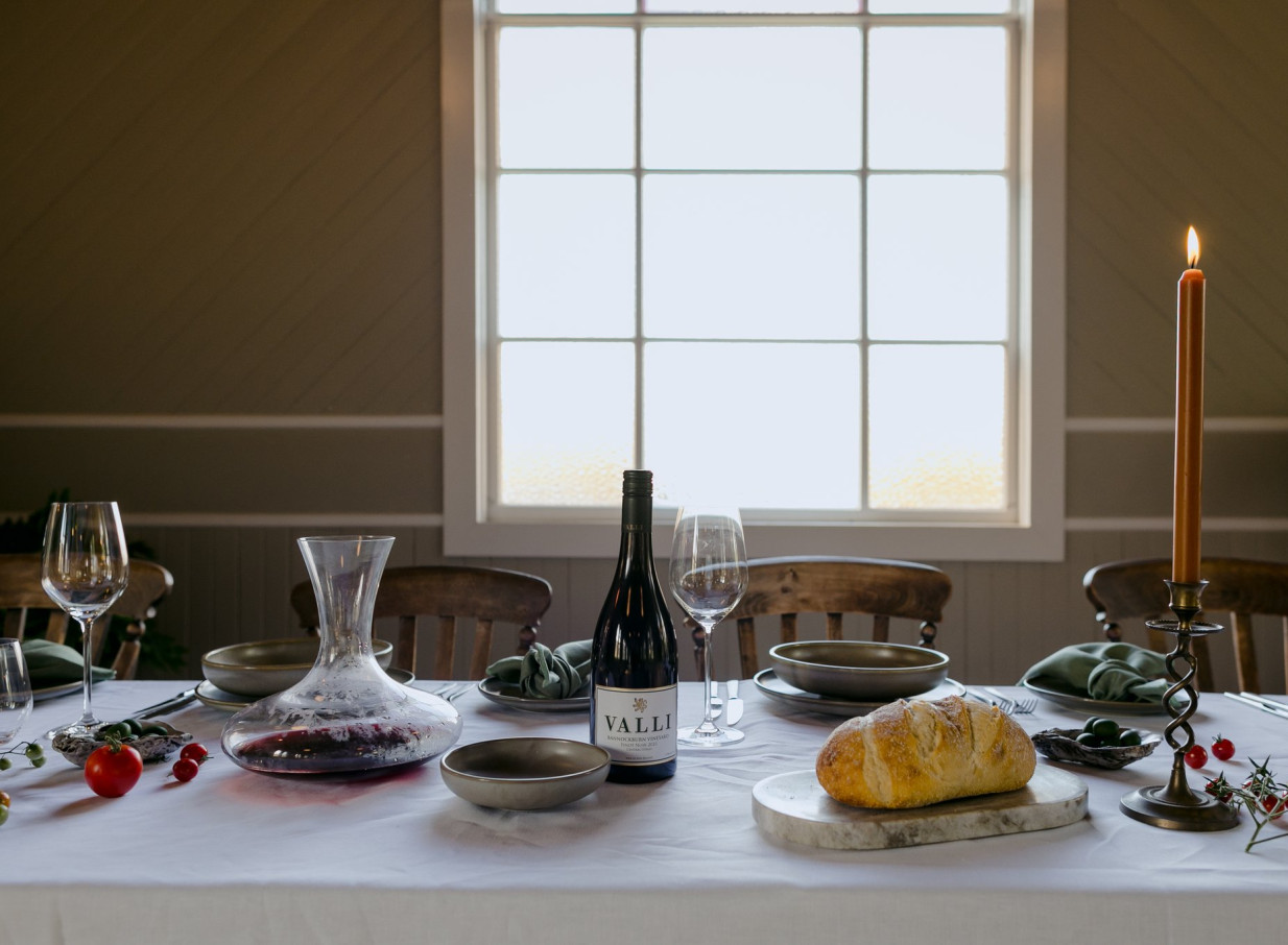 A beautifully set dining table within the restored century-old chapel of Waikākā Church in Queenstown.