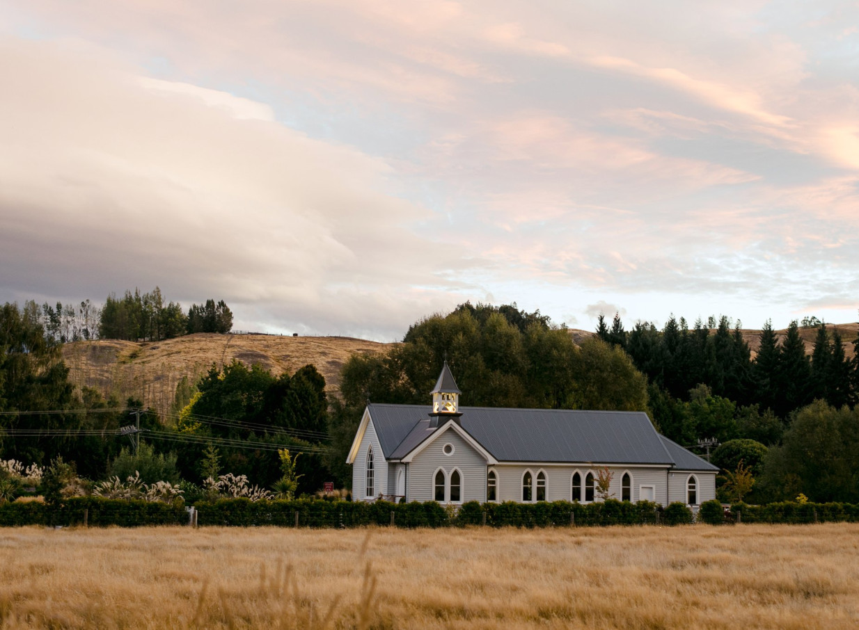 Waikākā Church in Queenstown is a beautifully restored century-old chapel, a picturesque venue nestled in a golden field.