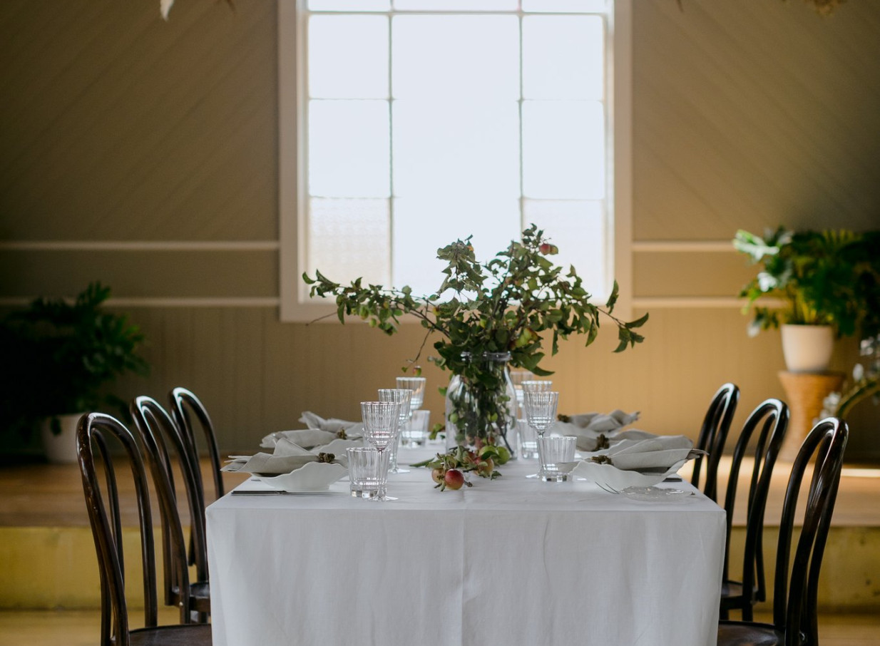 A beautifully set dining table within the bright, lovingly restored heritage interior of Waikākā Church in Queenstown.
