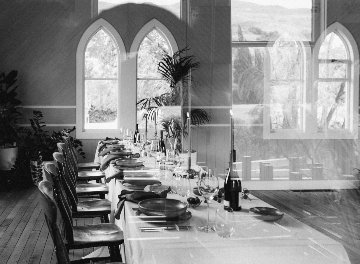 A private dining room is set within the restored historic chapel of Waikākā Church in Queenstown, featuring elegant arched windows.
