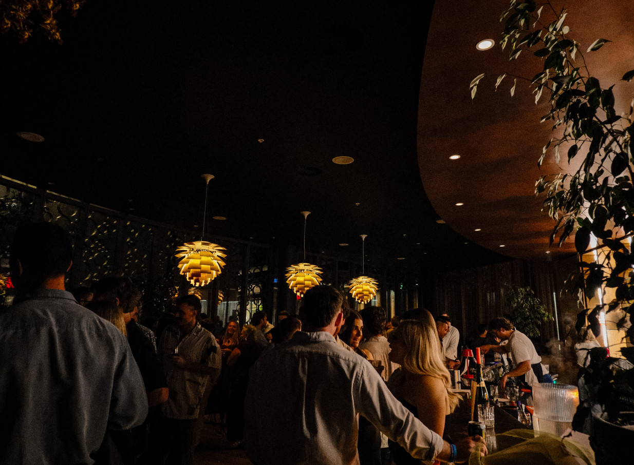 Guests enjoy drinks in the vibrant, modern Italian bar at Bar Franco in Christchurch, featuring distinctive lighting.
