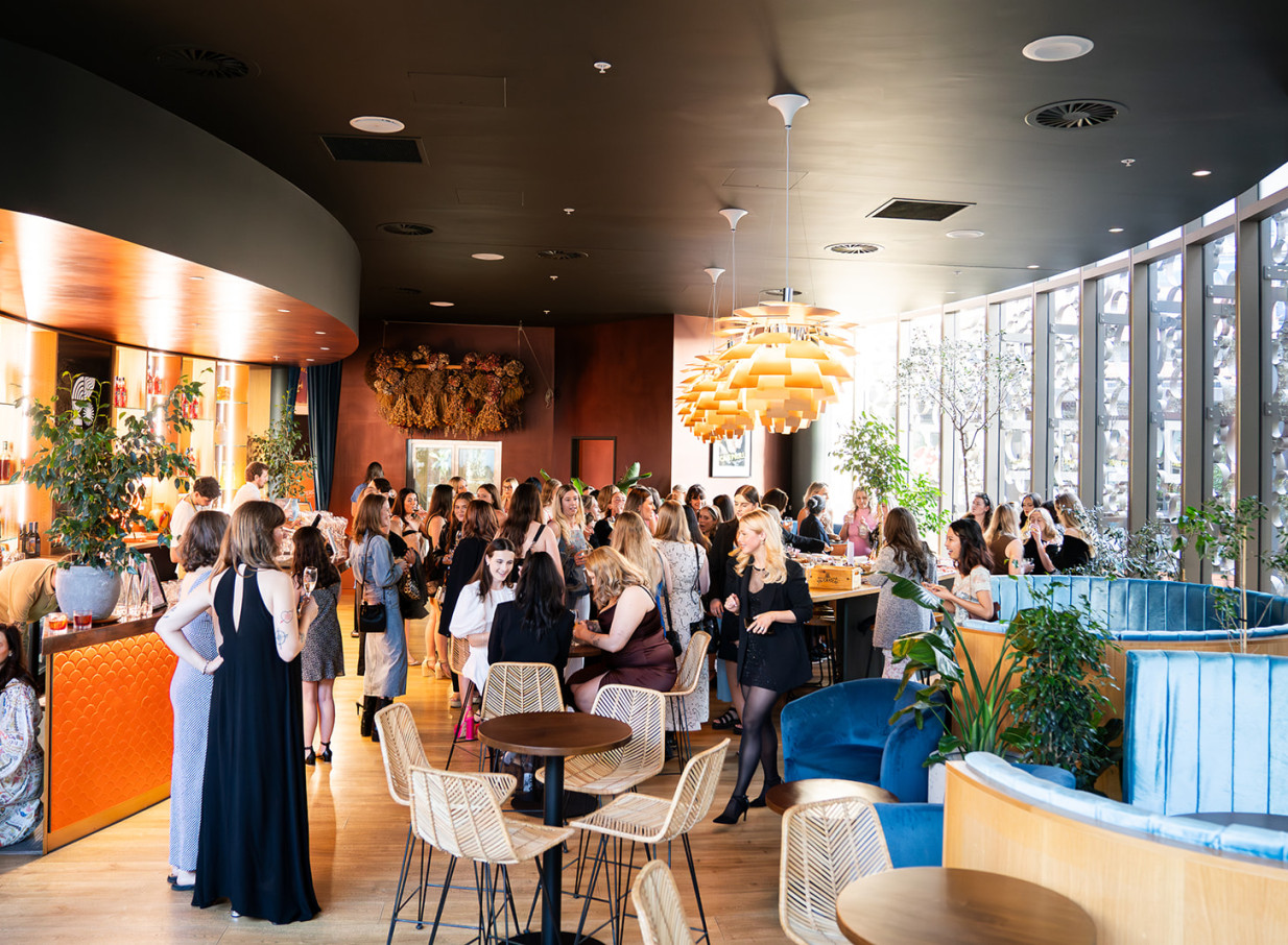A vibrant event fills Bar Franco's modern Italian bar in Christchurch, with guests mingling amidst stylish decor.