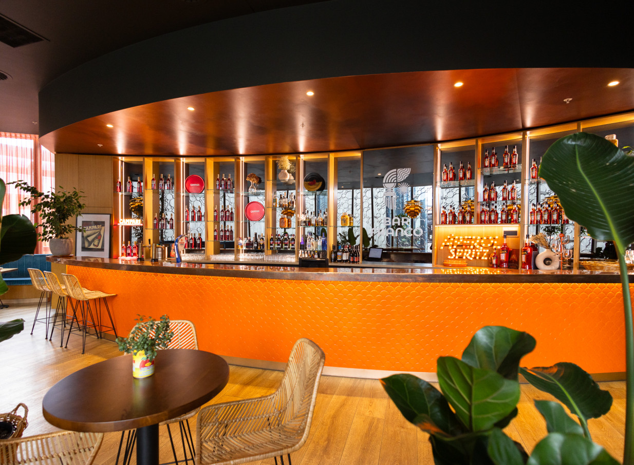 Bar Franco's vibrant, modern Italian bar in Christchurch, showcasing a textured orange counter and prominent Campari display.