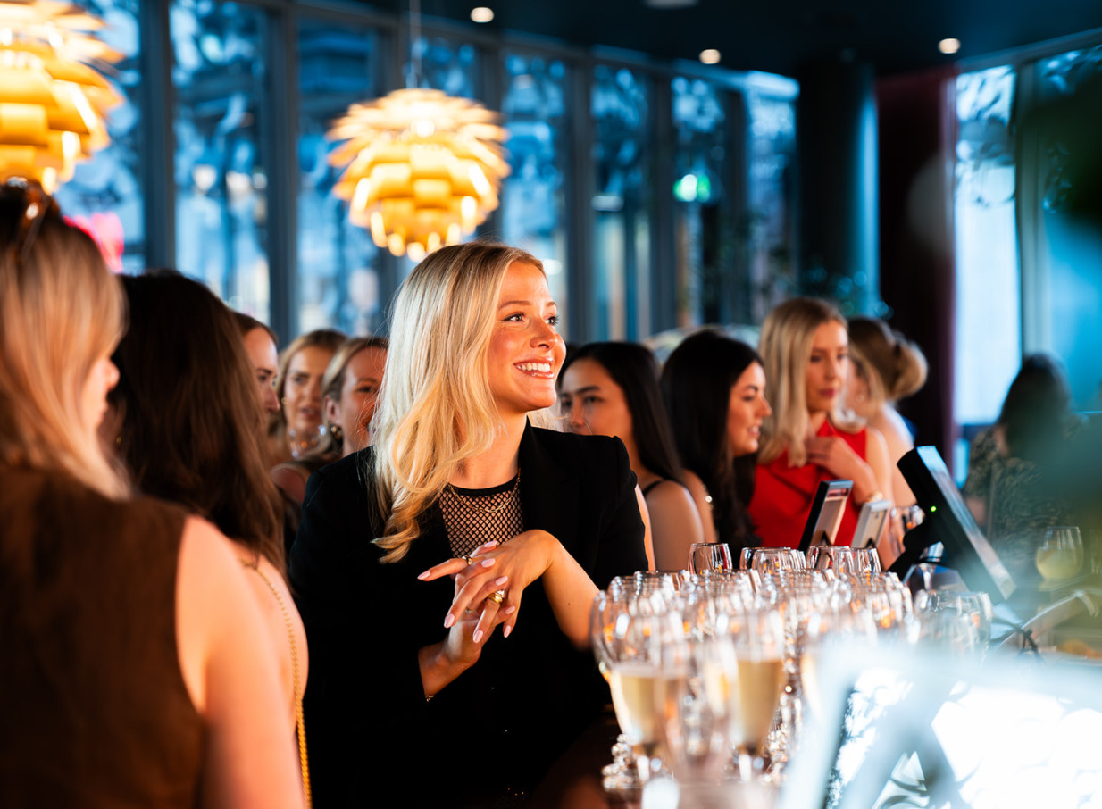 Smiling guests enjoy a vibrant, modern Italian bar experience at Bar Franco in Christchurch, featuring distinctive lighting.