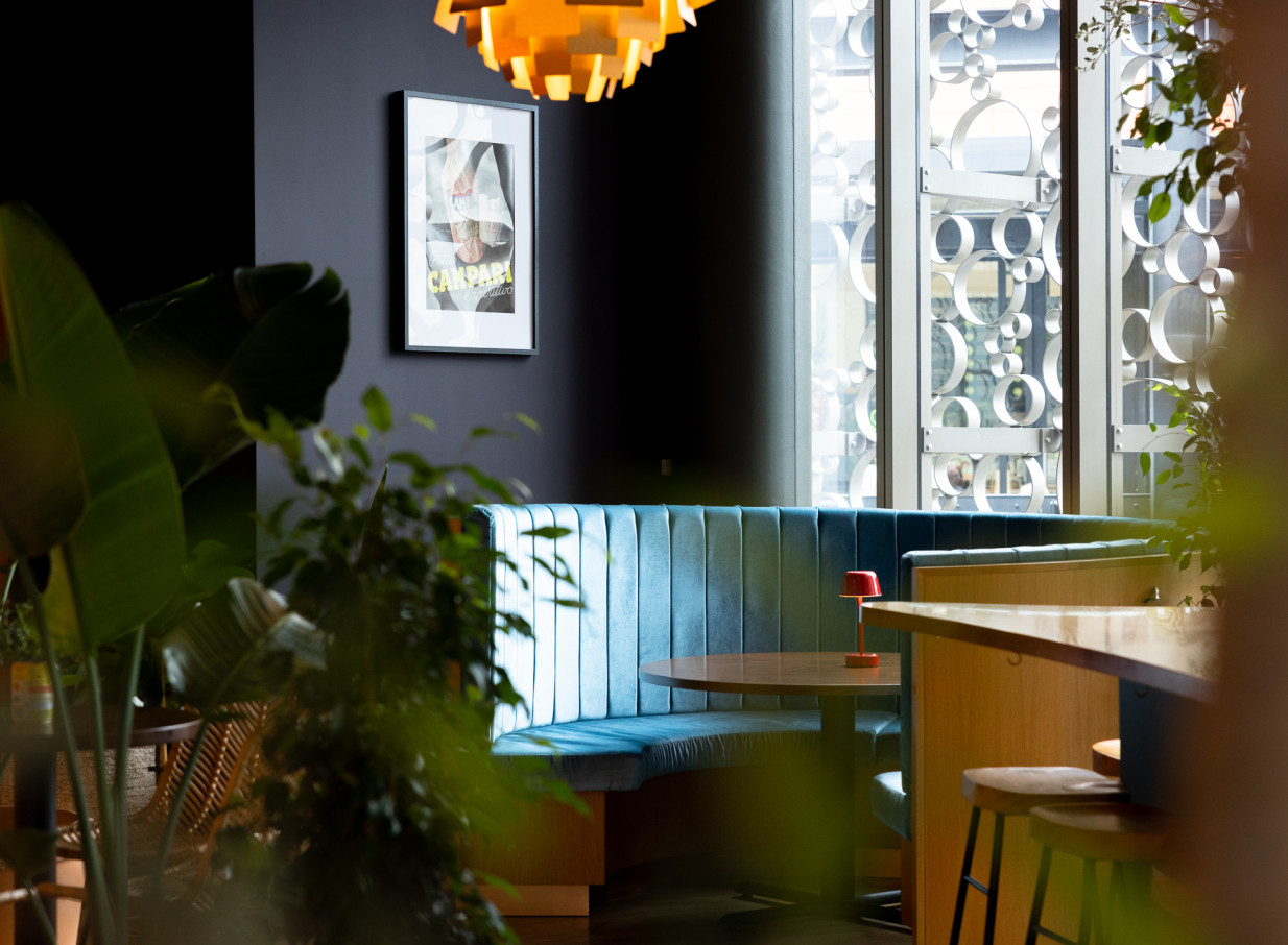 A lively booth seating area with a Campari print, reflecting Bar Franco's vibrant modern Italian and retro-chic style in Christchurch.