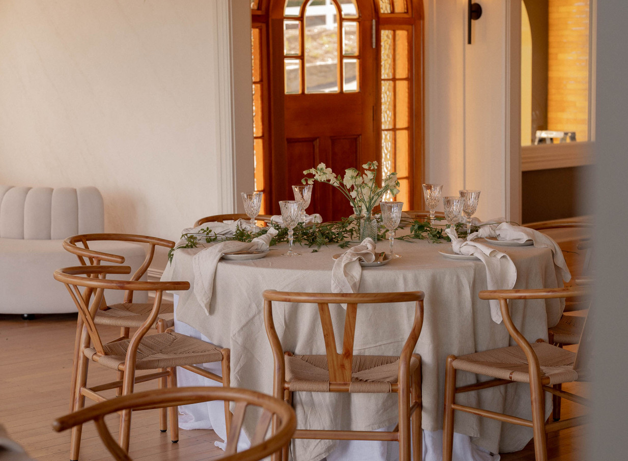 An elegant modern dining room at The Hilltop in Christchurch, featuring a round table set with wishbone chairs.