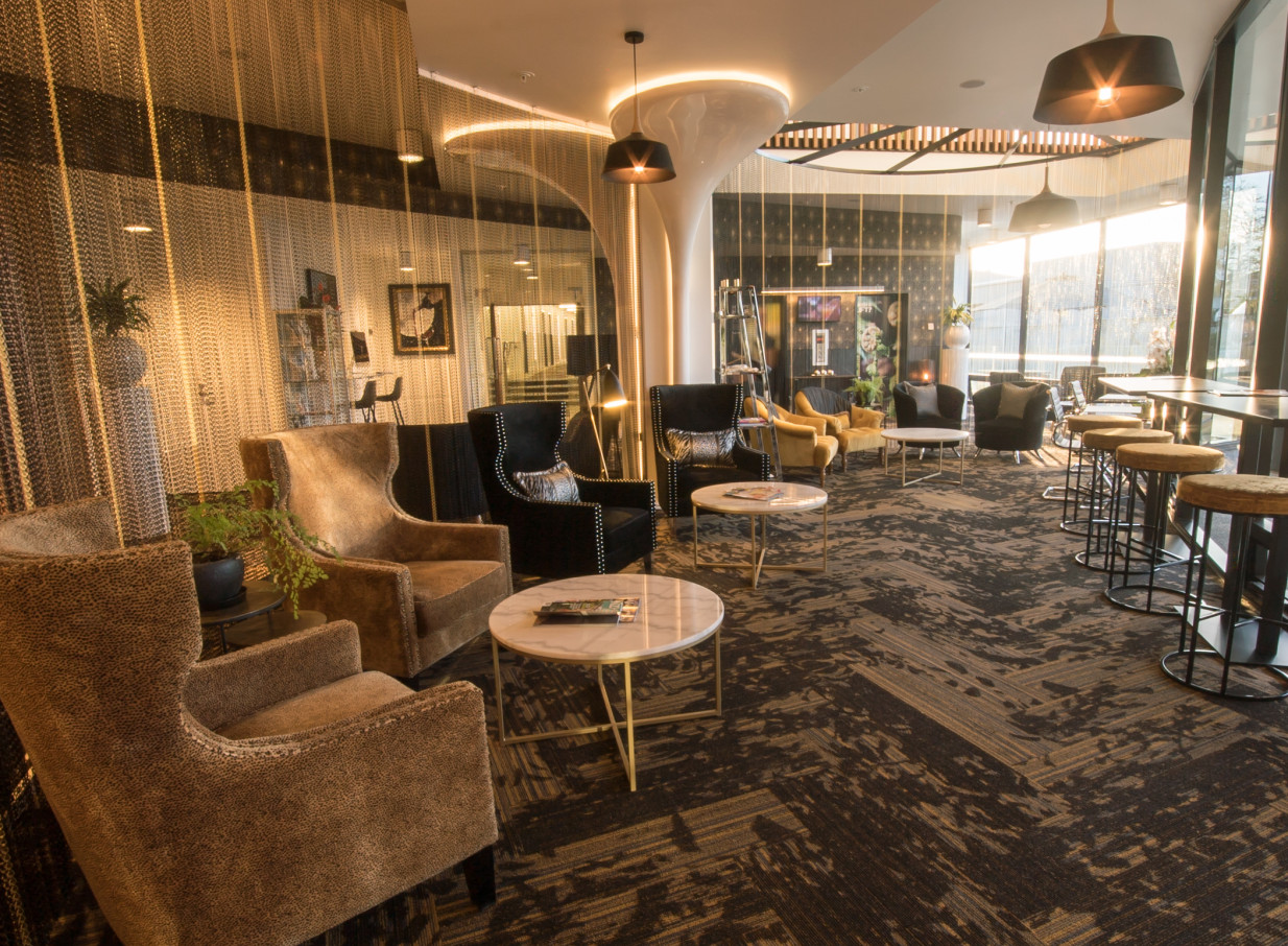 A stylish, contemporary lounge area with diverse seating at the Novotel New Plymouth Taranaki, featuring a modern design and upmarket, relaxed atmosphere.