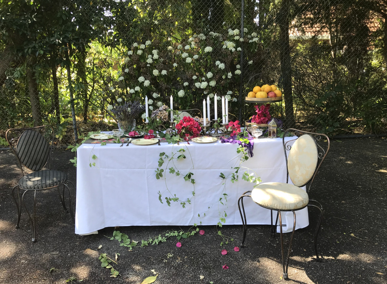 An outdoor table setting within the gracious, eclectic gardens of The 540 Lodge, Wellington, adorned with fresh florals.