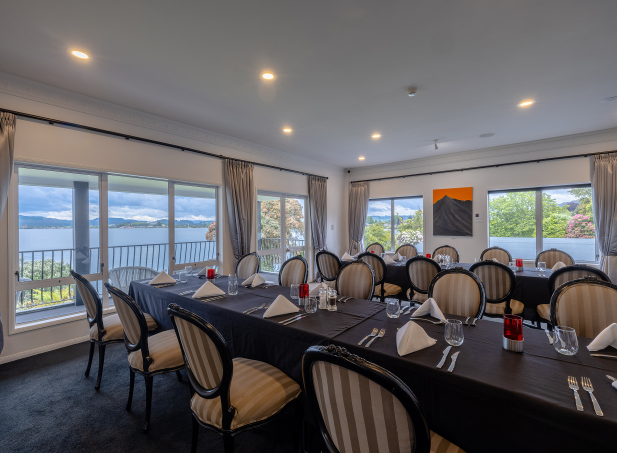 A sophisticated private dining room with panoramic lake views at the Black Swan Lakeside Boutique Hotel, Rotorua.