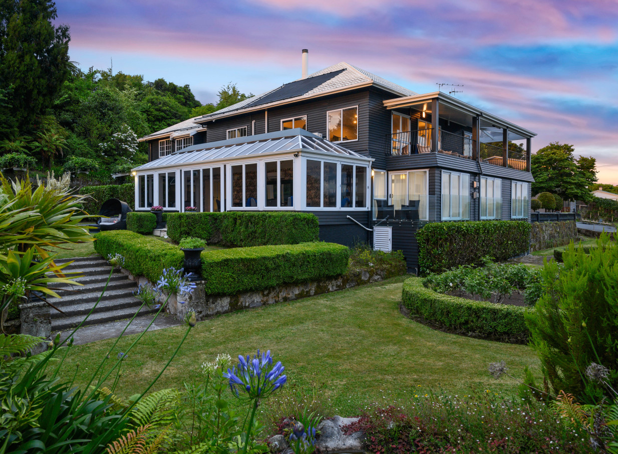 The Black Swan Lakeside Boutique Hotel, Rotorua, showcases its elegant exterior, Victorian gardens, and glass conservatory.