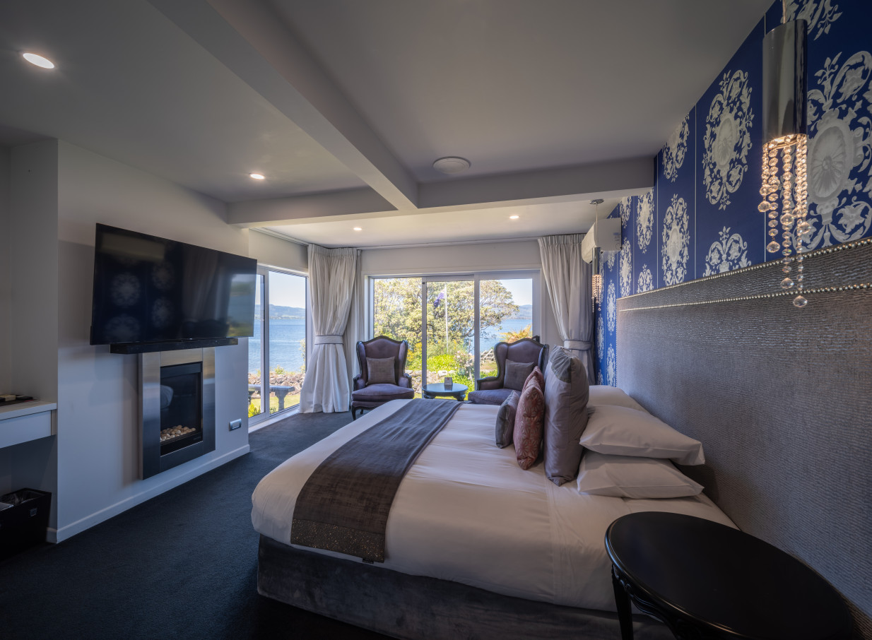 This luxurious, contemporary chic lakeside hotel bedroom at Black Swan Lakeside Boutique Hotel in Rotorua offers stunning views and elegant decor.