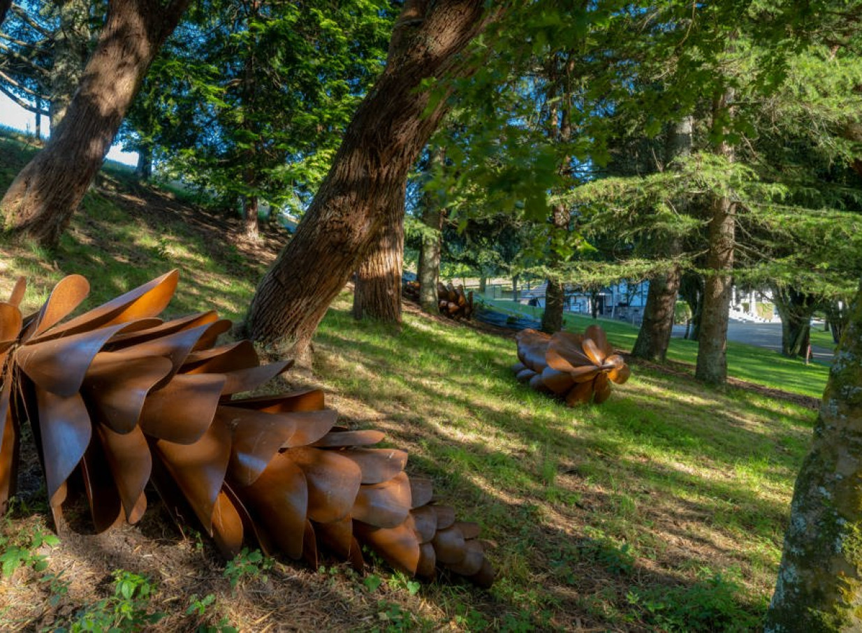 An artistic metallic pinecone sculpture nestled in the natural landscaped gardens of Hana Lodge, Rotorua.