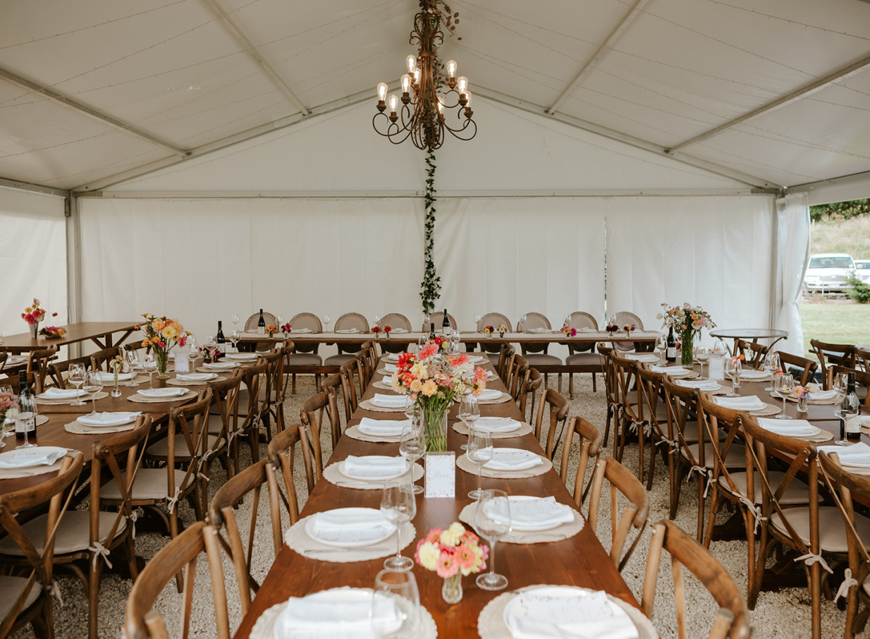 A beautifully set reception dining area within a white marquee, capturing the French countryside charm of Villa Vie in Bay of Plenty.