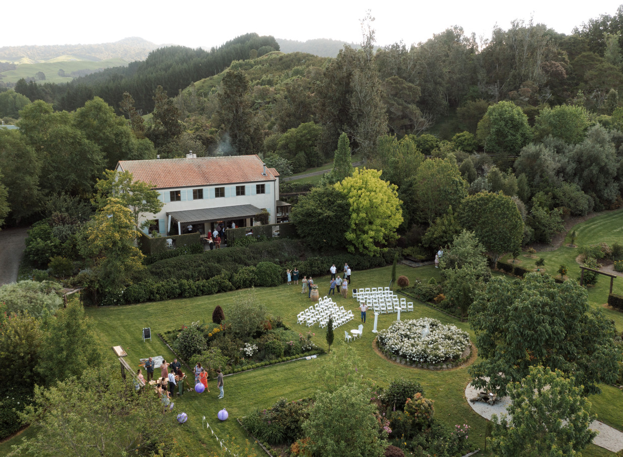 An outdoor wedding ceremony is set up on the manicured lawns of Villa Vie, a French-style homestead in Bay of Plenty.
