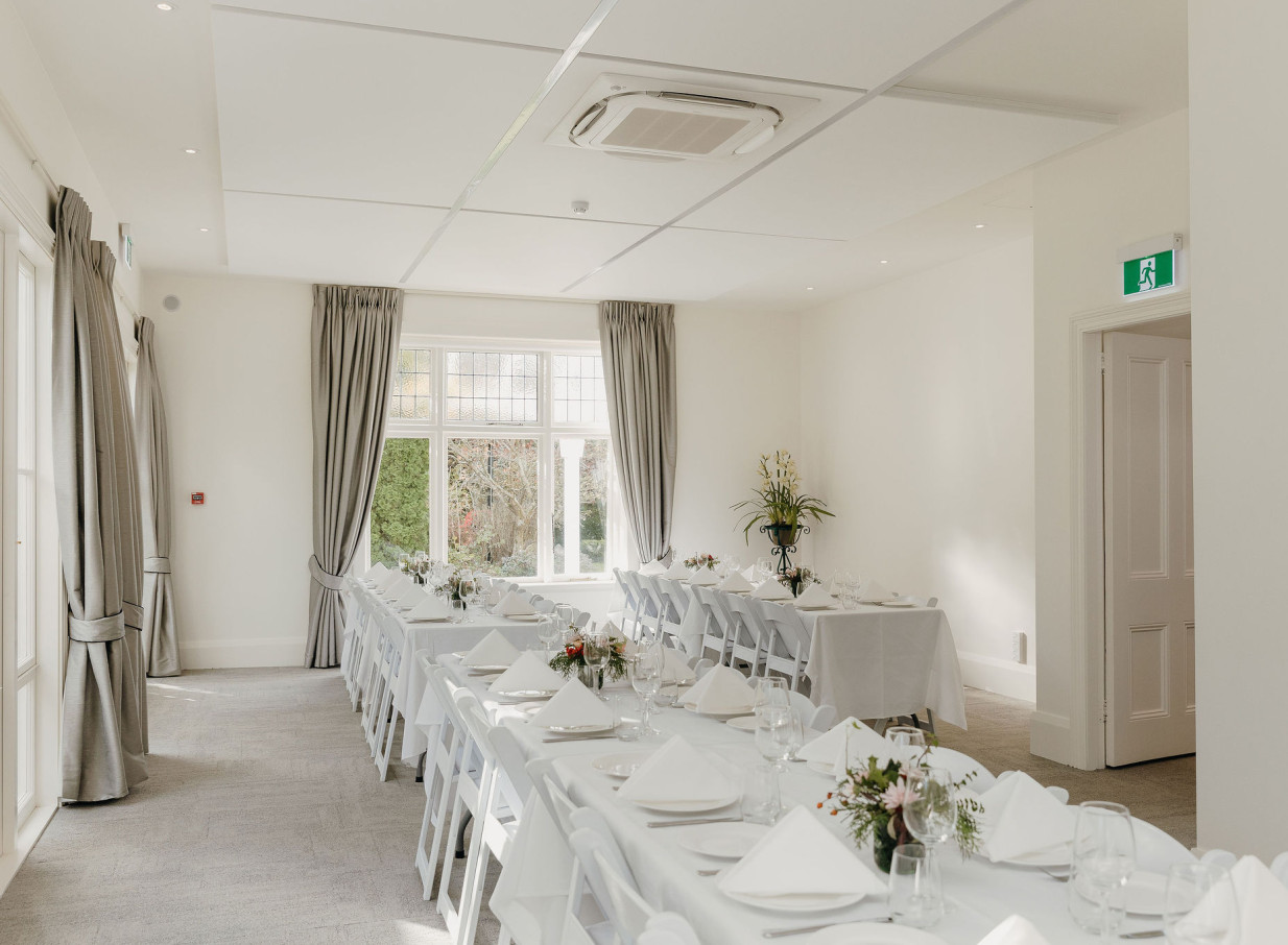 A reception room in the elegant historic kauri villa, Kate Sheppard House, Christchurch, set for dining.