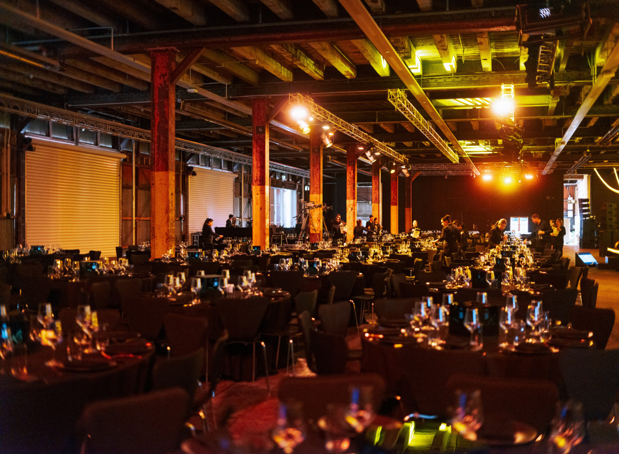 Shed 10, Auckland's industrial-chic heritage venue, set for a formal dinner with exposed beams and columns.