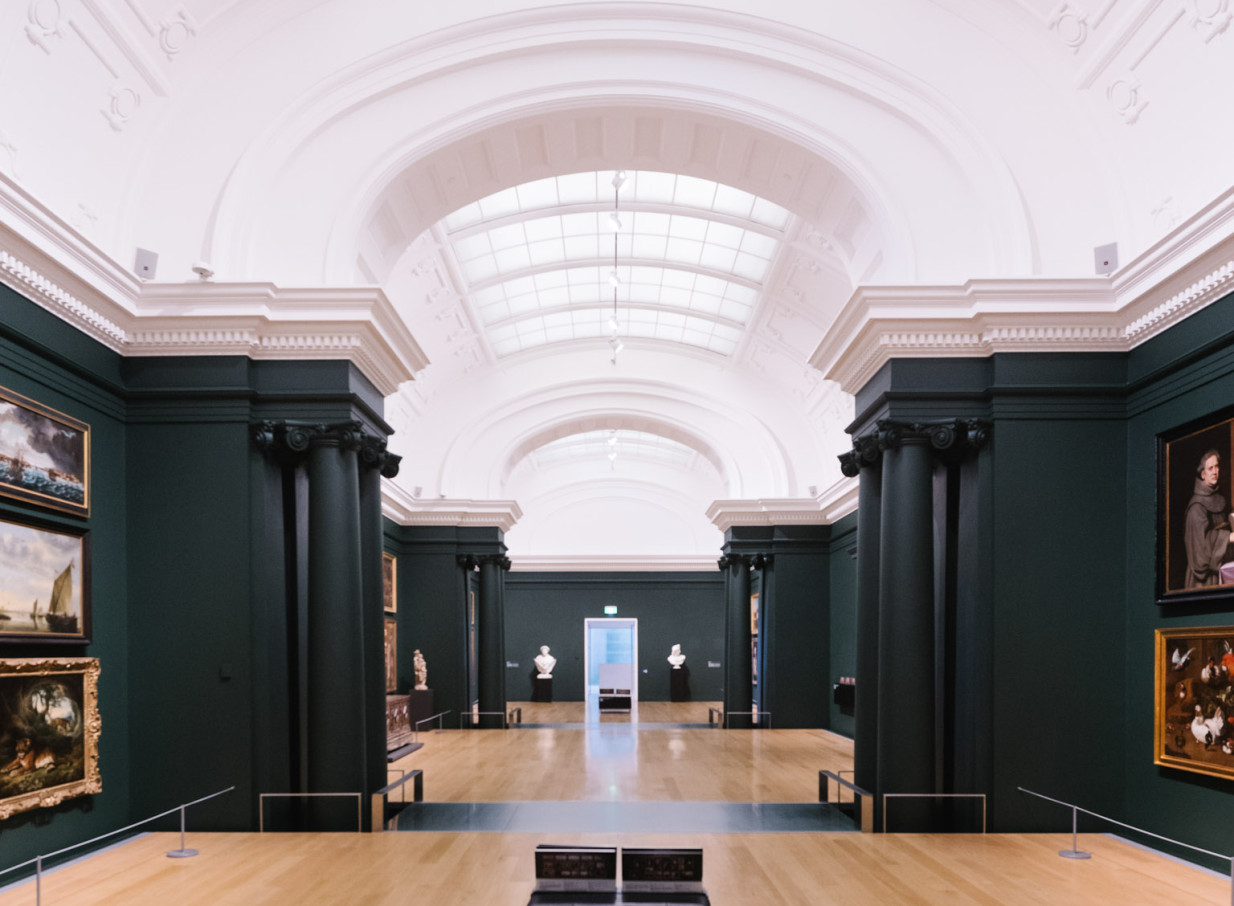 A French Renaissance-style gallery interior at Auckland Art Gallery Toi o Tāmaki, Auckland, featuring dark green walls and arched skylights.