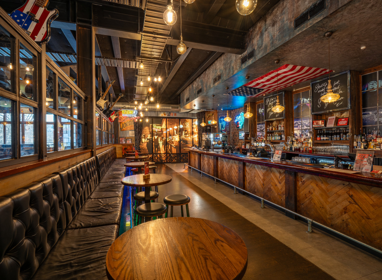 Fat Eddie's, an American-inspired jazz bar in Christchurch, boasts a lively atmosphere with tufted booths and a long wooden bar.