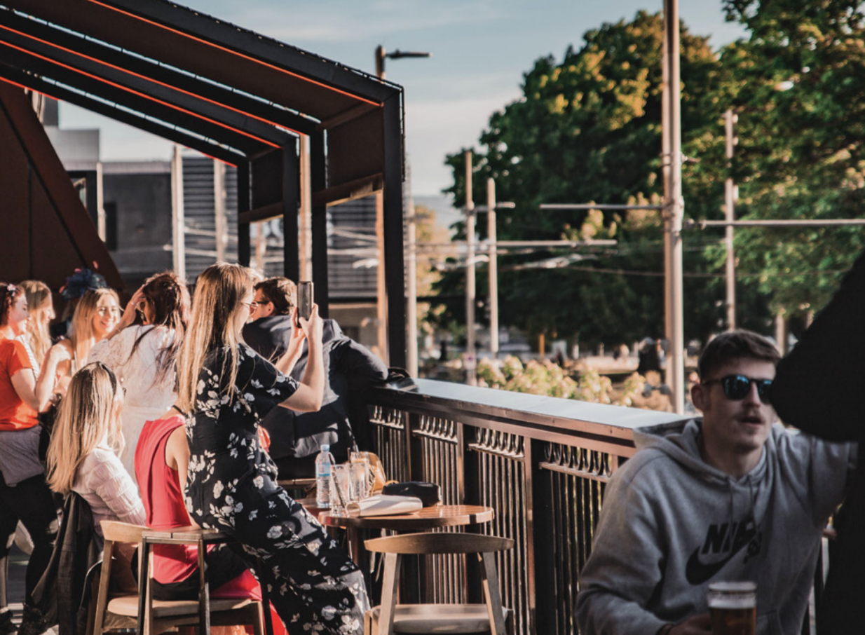 Guests enjoy drinks and the lively atmosphere on the modern urban terrace of Fat Eddie's, Christchurch.
