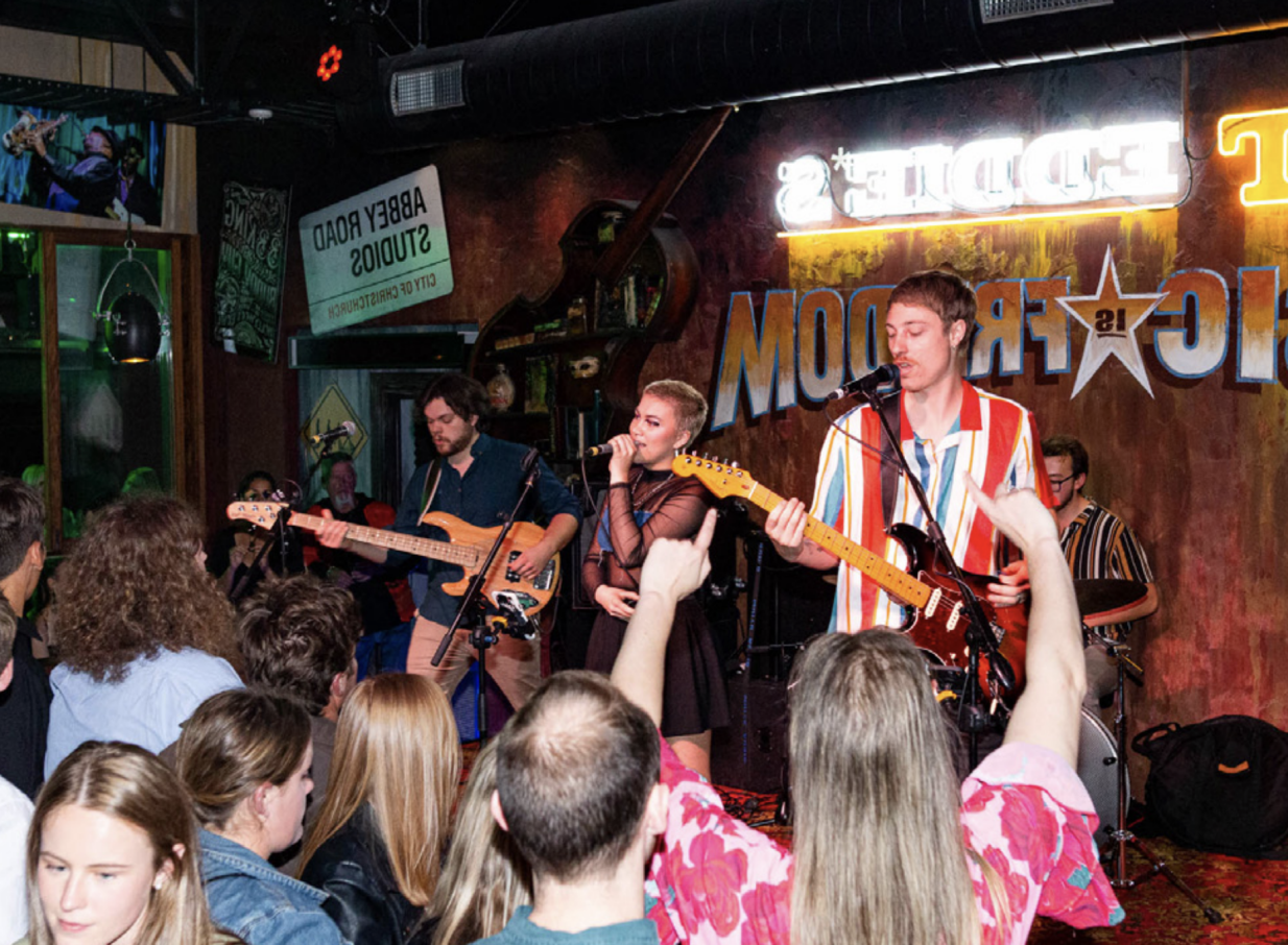 A live band performs in the vibrant, neon-lit jazz club, Fat Eddie's in Christchurch.