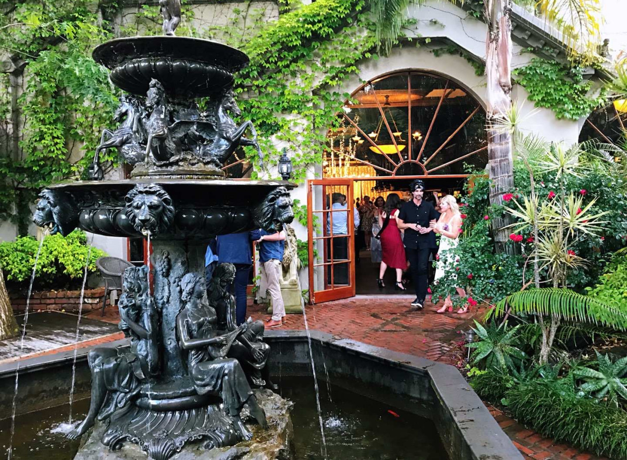 Guests enter the elegant heritage venue, Settlers Country Manor in Auckland, from its lush garden courtyard with an ornate fountain.