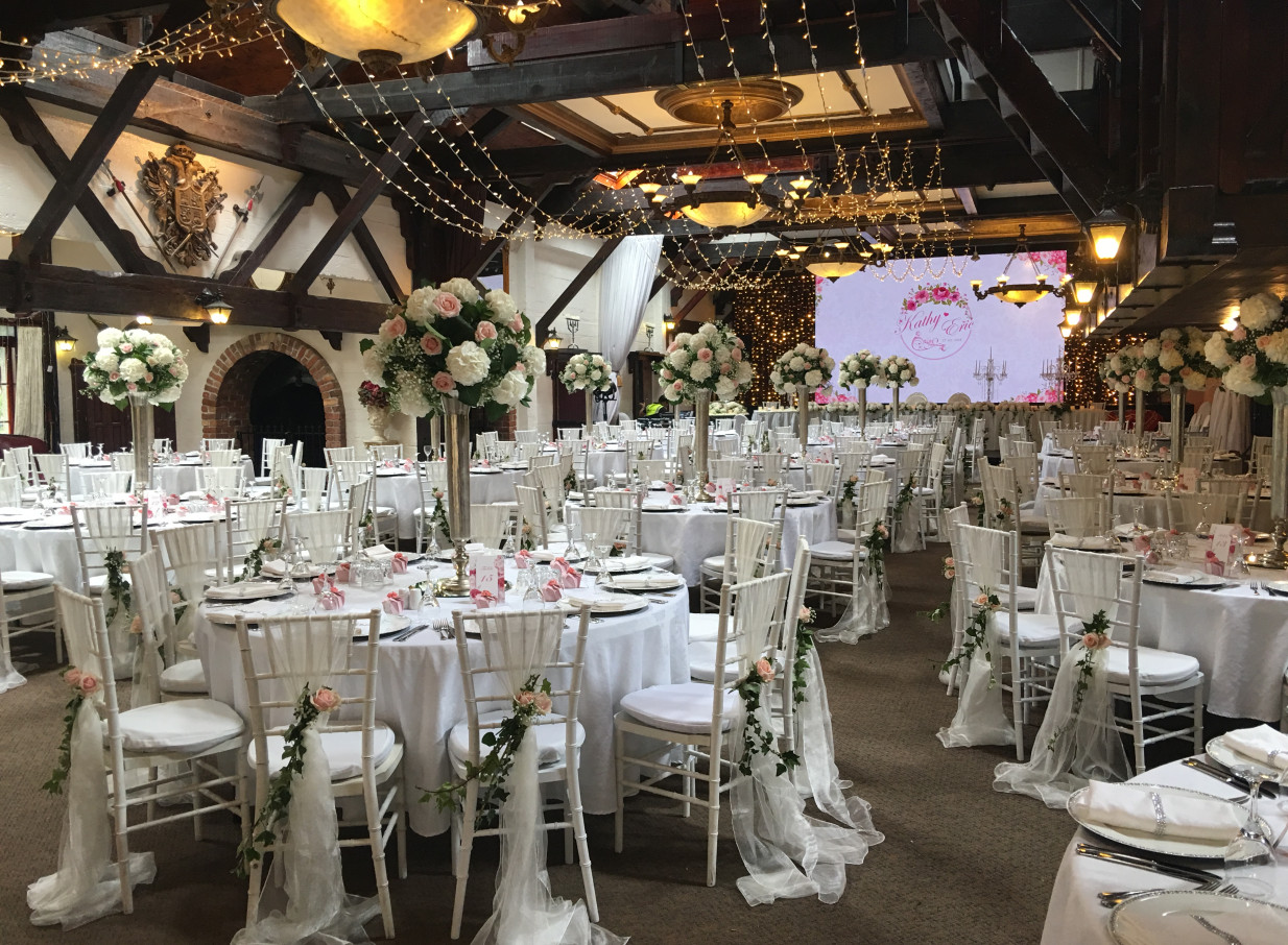 An elegant wedding reception in Settlers Country Manor's rustic heritage banquet hall in Auckland, with timber beams and festive lights.