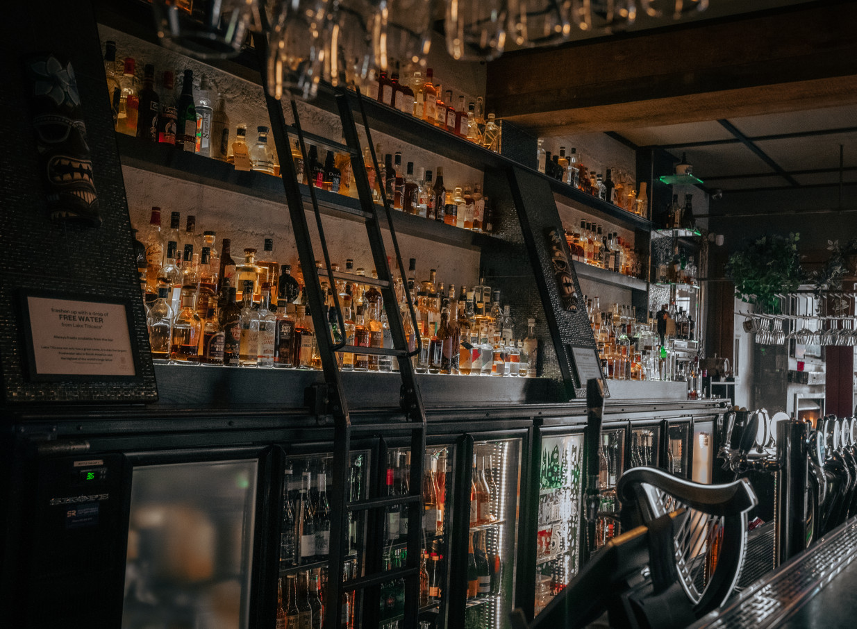 An old-world Latin American-inspired bar interior at Casa Publica, Christchurch, displaying its vast rum collection.