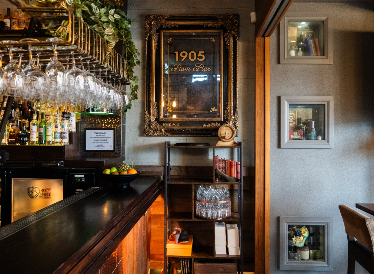 Casa Publica in Christchurch's moody, South American-inspired rum bar features hanging glasses and a prominent "1905 Rum Bar" mirror.