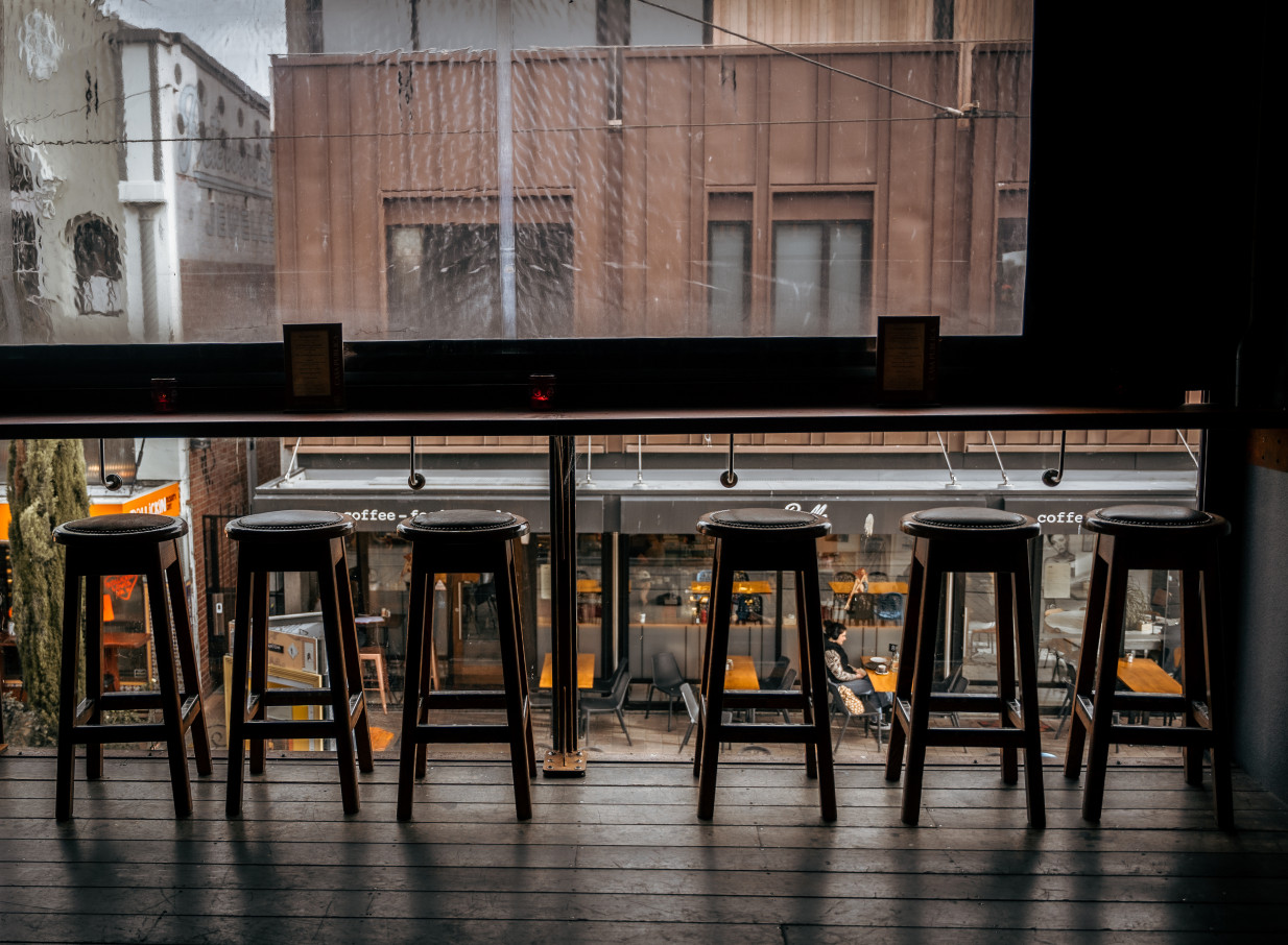 A moody, South American-inspired bar seating area at Casa Publica in Christchurch overlooks the street scene.
