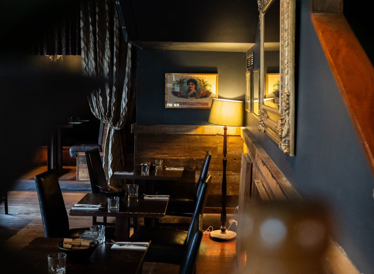 An intimate, moody dining room with South American and Prohibition-era style at Casa Publica, Christchurch.