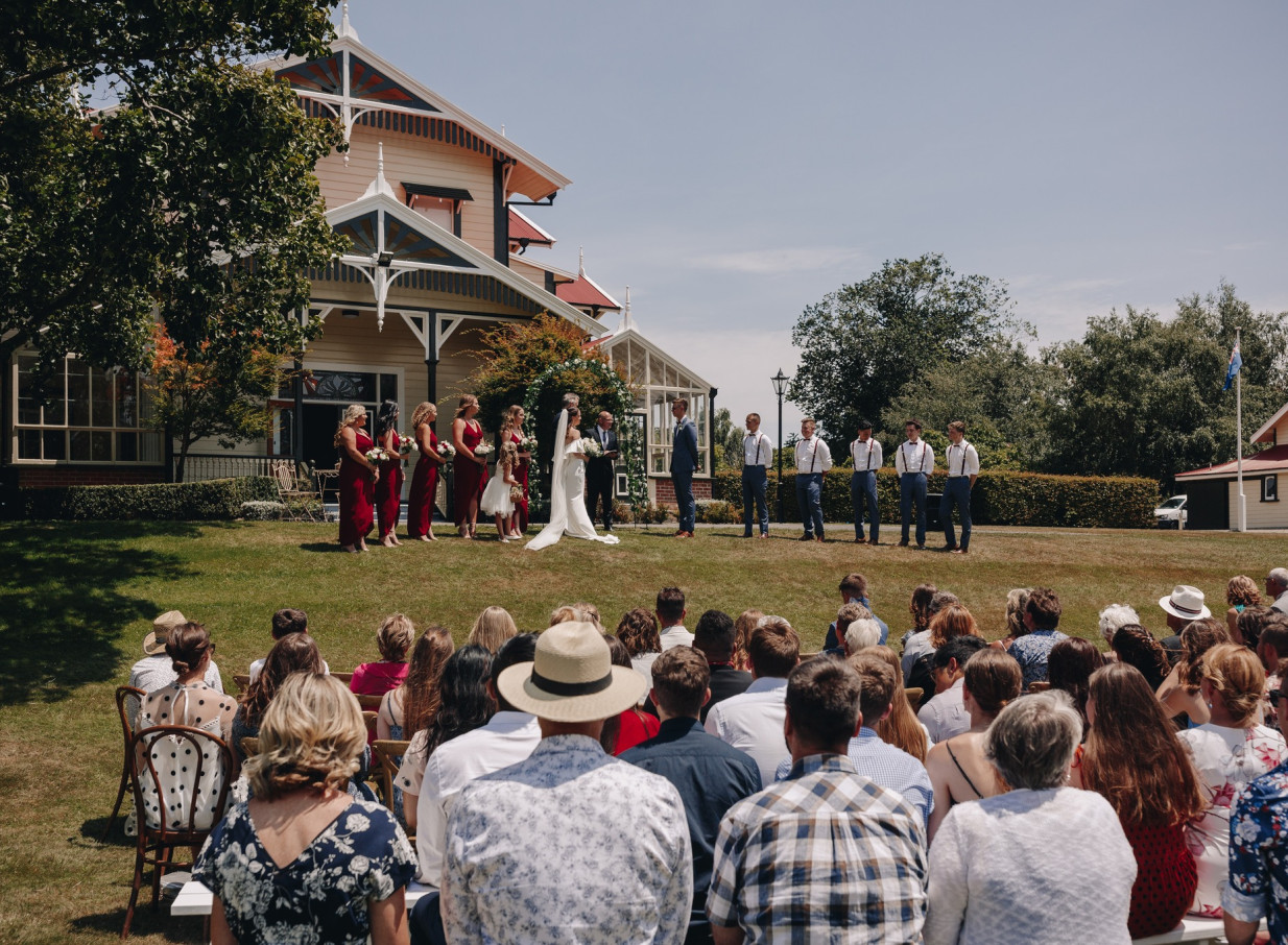 An outdoor wedding ceremony at Caccia Birch House, an elegant 19th-century heritage homestead in Manawatū-Whanganui.