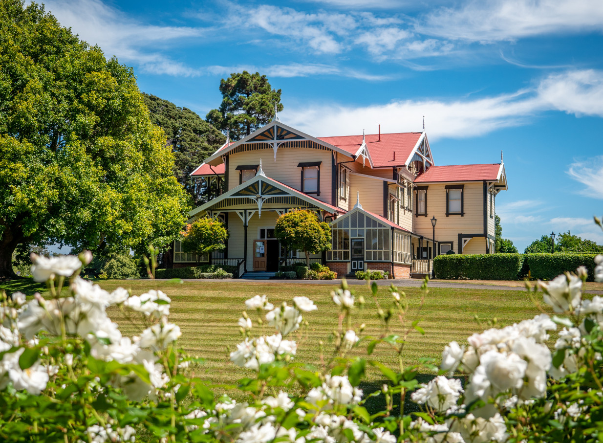 Caccia Birch House, a colonial homestead in Manawatū-Whanganui with Scandinavian design elements, stands elegantly amidst green lawns.