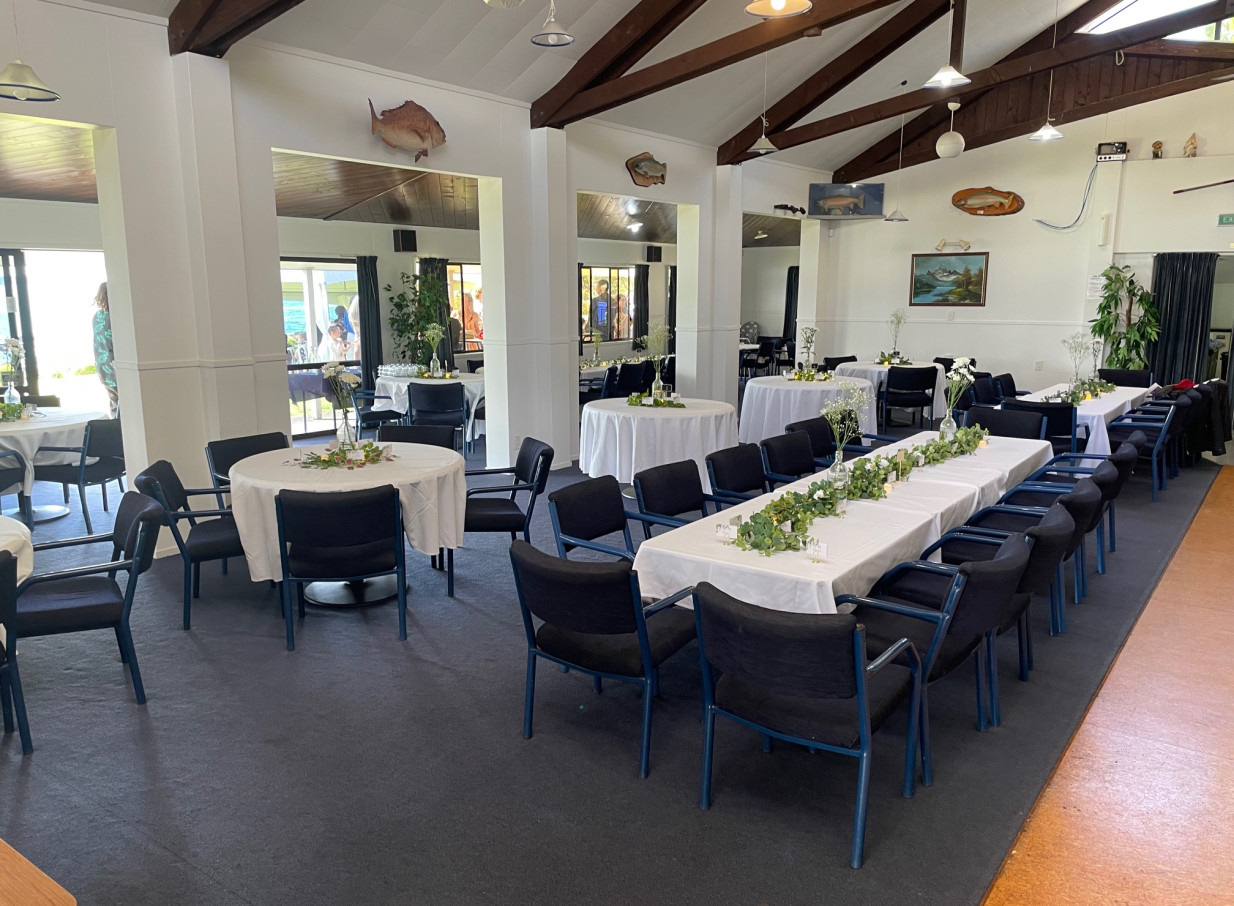 A coastal club-style dining event at Tauranga Fish and Dive Club, Tauranga, featuring a spacious hall with mounted fish.