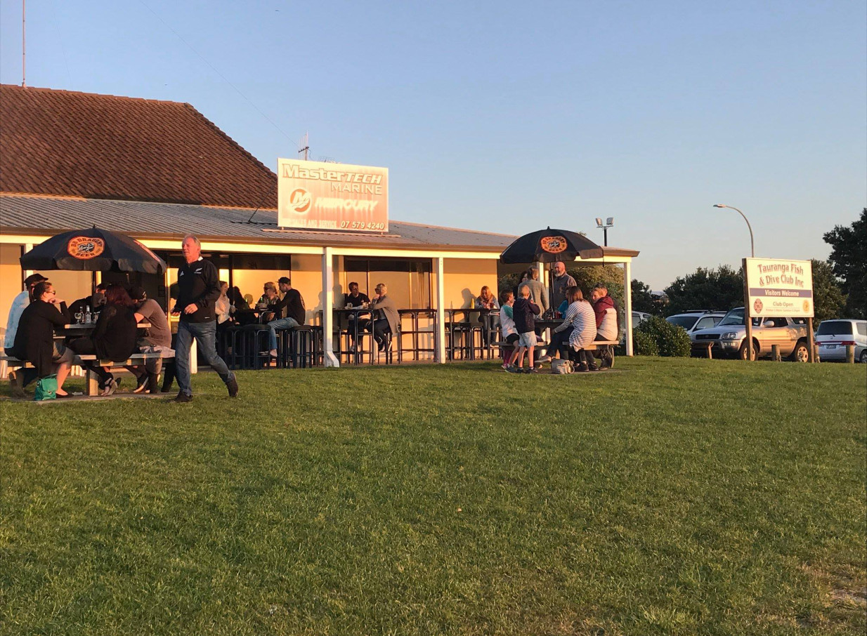 Patrons enjoy the casual outdoor dining area of the relaxed coastal clubhouse at the Tauranga Fish and Dive Club in Tauranga.