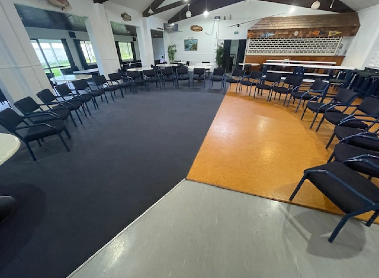 A spacious, relaxed coastal-style meeting hall at Tauranga Fish and Dive Club, Tauranga, with chairs arranged for an event.
